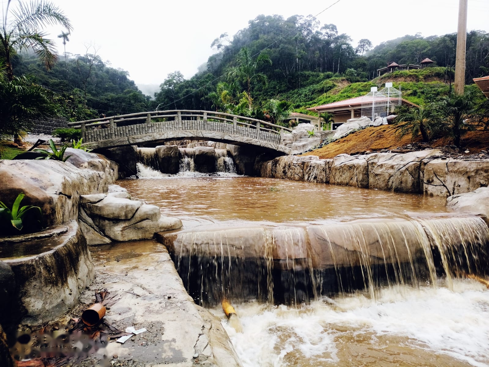 Puente de piedra sobre río y cascadas naturales