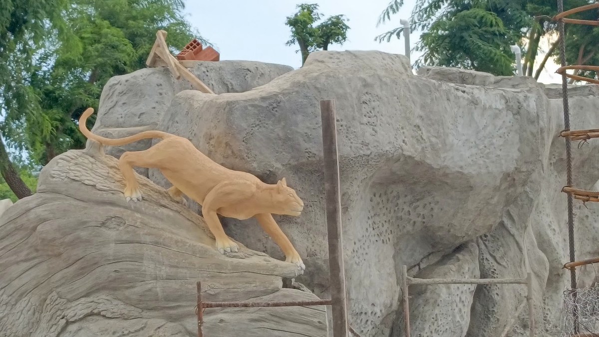 Escultura de Puma en roca artificial sobre piscina
